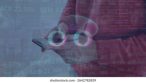 Man wearing red sweater holding smartphone at chest in grey studio, with AR rings and codes. Technology, data visualization, innovation, digital interface, futurism, analytics, wearable tech