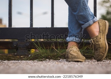 A man wearing rolled up jeans and boat shoes