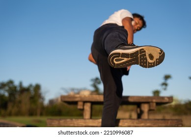 A Man Wearing Running Shoes With Worn-out Outsole Is Kicking In The Air