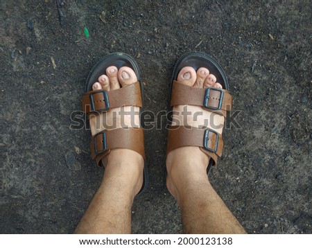 A man wearing sandals outside the house