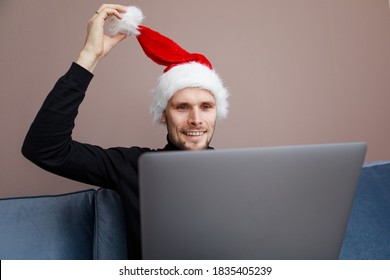 Man Wearing Santa Hat. Business Video Conferencing. Young Man Having Video Call Via Computer In The Home Office. Virtual Christmas House Party. Online Team Meeting Video Conference Calling From Home. 