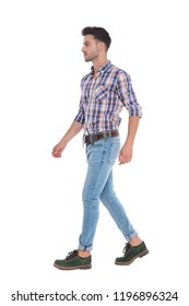 man wearing a shirt with red checkers walks to side on white background, full length picture