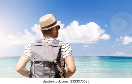 Man wearing straw sun hat with backpack walking on the beach on background of seascape. - Powered by Shutterstock