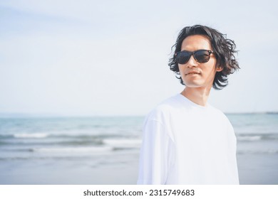 Man wearing sunglasses walking on beach in summer - Powered by Shutterstock