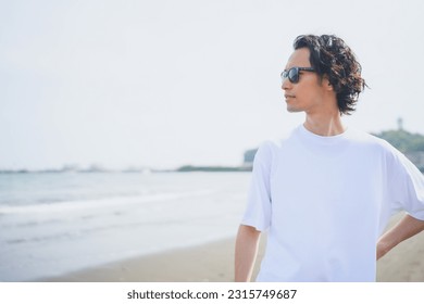 Man wearing sunglasses walking on beach in summer - Powered by Shutterstock