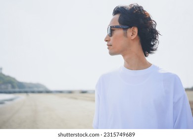 Man wearing sunglasses walking on beach in summer - Powered by Shutterstock