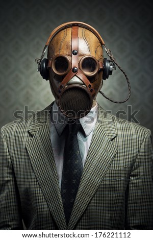 Man wearing vintage gas mask and headphones listening to music.