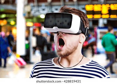 Man wearing virtual reality goggles standing at train station