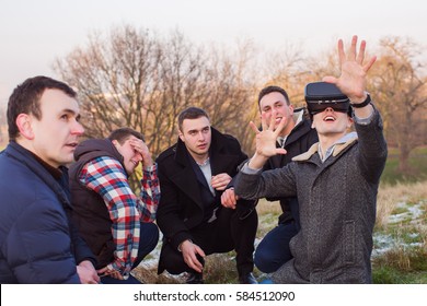 Man Wearing Virtual Reality Goggles. Group Of People Having Fun Outdoor