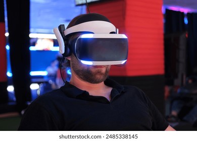 Man wearing VR Glasses. Surprised adult male having fun play VR headset virtual reality goggle, 3D cyber space. Neon blue red UV lighting. Digital technology, game - Powered by Shutterstock