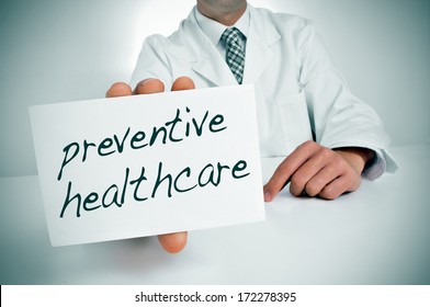 A Man Wearing A White Coat Showing A Signboard With The Text Preventive Healthcare Written In It