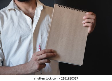 Man Wearing White Shirt Holding Brown Paper Notebook Black Background