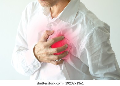 A man wearing a white shirt is sick and in pain and presses his chest with his hands. He had chest pain caused by an acute heart attack. There were red dots on his chest indicating pain.