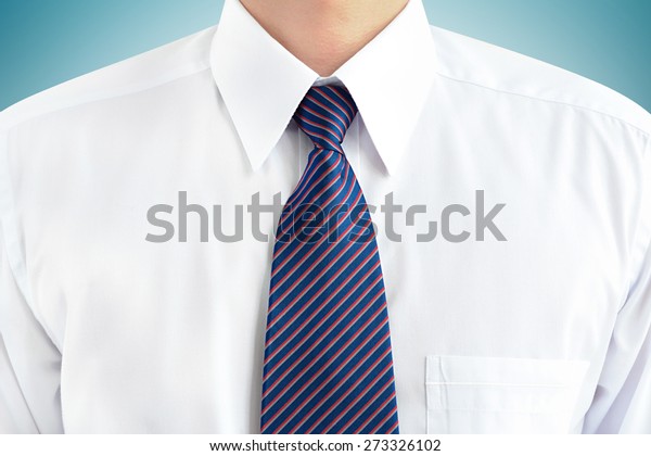 A\
man wearing white shirt and striped tie - soft\
focus