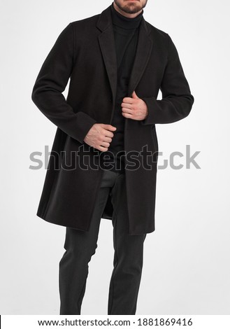 man wears black overcoat. isolated studio shot of stylish man in dark full length greatcoat
