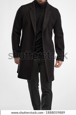 man wears black overcoat. isolated studio shot of stylish man in dark full length greatcoat