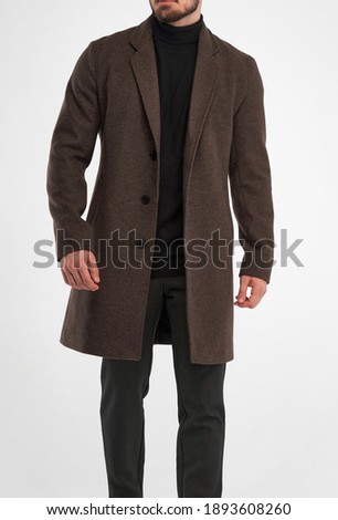 man wears brown overcoat. isolated studio shot of stylish man in dark full length dark brown greatcoat