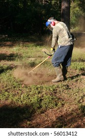 A Man Wears His Protective Gear As He Cuts Brush With His Weed Wacker