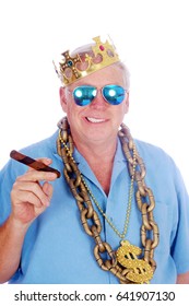 A man wears a King Crown, Gold Chains, Sunglasses and smokes a Big Cigar. Isolated on white. Room for text. 