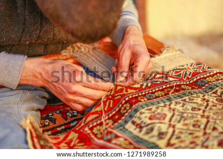 man weaving carpet