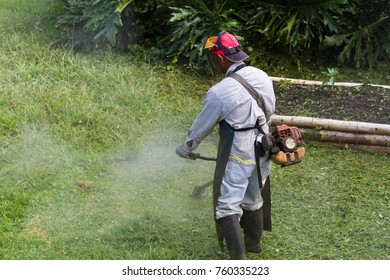 Man With A Weed Whacker Mowing The Lawn In A Large Yard In Costa Rica