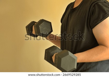 Man weight training using 8kg dumb bells