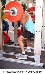 Man Weightlifting Barbells At A Squat Rack In A Gym