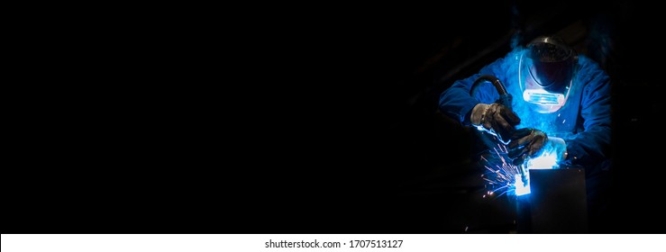 Man Welding In A Fabric With Sparks, Dark Background