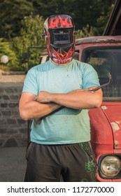 Man With A Welding Mask On His Head In Front Of A Vintage Rusty And Destroyed Truck Or Van. Car Restoration In Progress. Tough Guy Restoring A Car