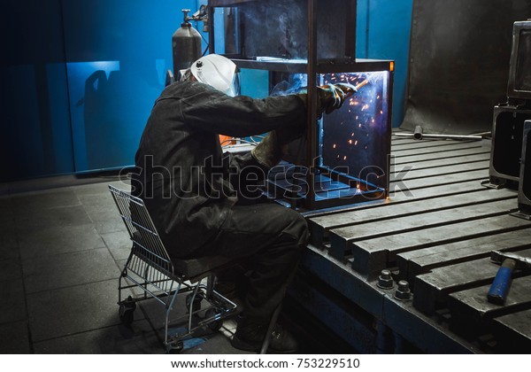 A man\
with a welding mask welding something\
together