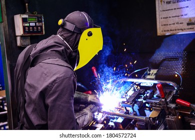 Man Welding On Assembly Line In Automotive Factory .