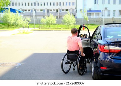 a man in a wheelchair closes the door of his car, driver with disability - Powered by Shutterstock