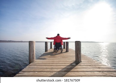 man in wheelchair enjoying his freedom at lake - Powered by Shutterstock