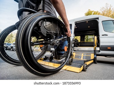A man in a wheelchair moves to the lift of a specialized vehicle 