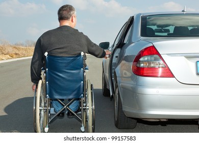 Man In A Wheelchair Next To His Car