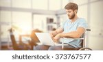 Man in wheelchair using computer against board room
