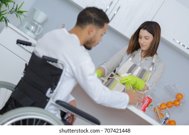man in wheelchair while girlfriend is preparing food