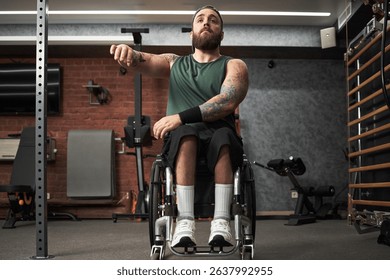 Man in wheelchair working out in contemporary gym setting with various fitness equipment and workout gear visible. Focused and determined expression on mans face as he exercises