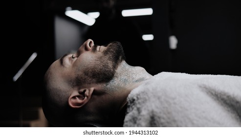 Man While Barber Applying Shaving Cream On His Beard And Neck Using Shaving Brush.