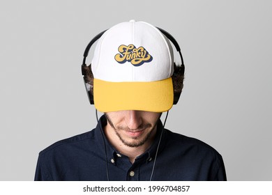 Man With A White Cap Mockup And Headphones On A Gray Background