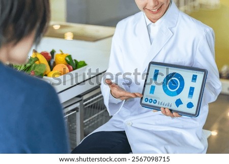 A man in a white coat explaining a tablet screen