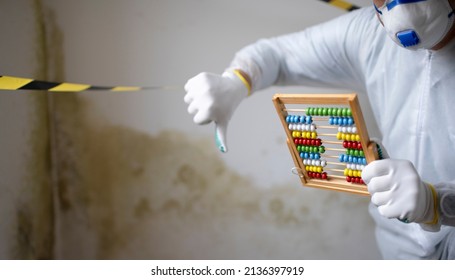 Man With White Protective Suit With Abacus Calculator, Slide Rule In Hand And Mouth Nose Mask In Front Of Yellow Black Barrier Tape In Front Of Wall With Mildew