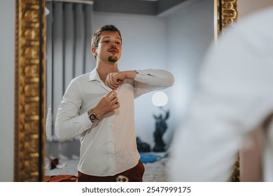 A man in a white shirt adjusts his collar while looking in the mirror, getting ready for a night out. The scene shows anticipation and attention to detail. - Powered by Shutterstock