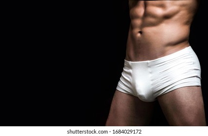 Man In White Shorts. Handsome Muscular Macho In White Underwear. Male Swimwear, Shorts, Underwear, Concept. Male Muscular Body In White Sexy Underpants. Copy Space.