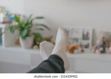 Man In White Socks On Feet In Pants Resting In Room Lying On Couch