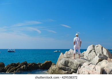 Man in white suit at the beach looking at the sea - Powered by Shutterstock