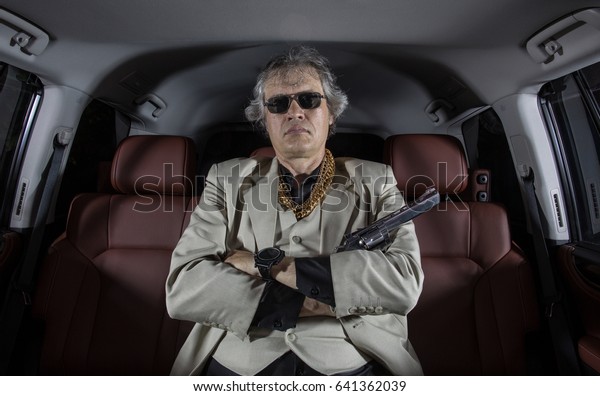Man\
in a white suit with a gun, ganster, mafia in the\
car