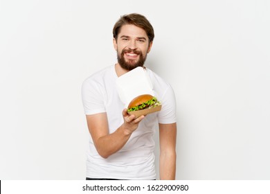 A man in a white T-shirt and a hamburger paper box