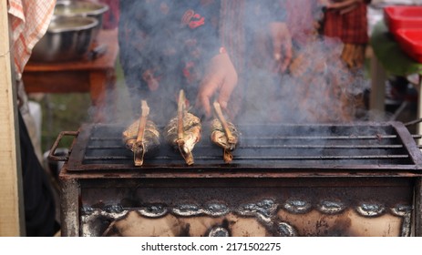 A Man Who Is Grilling Fish Traditionally Uses A Grill To Sell And See The Smoke. 