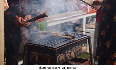 A Man Who Is Grilling Fish Traditionally Uses A Grill To Sell And See The Smoke. 